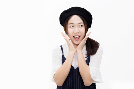 Young and pretty Asian woman in surprised and amazed expression in white isolated backgroundの写真素材