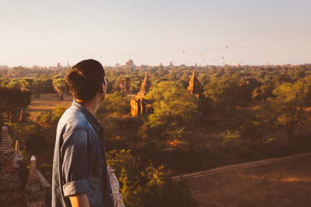 Silhouette of young male backpacker watching sunset and pagoda in Bagan, Burmaの写真素材