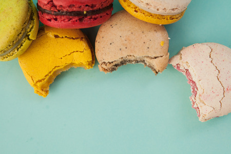 Pile of colorful macaroons stacked up like a tower in blue turquoise pastel isolated backgroundの写真素材