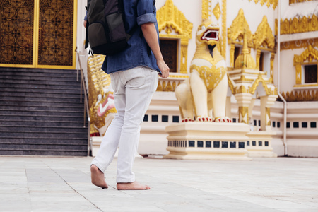 Back of young man backpacker walking towards Burmese temple named Buddha  Relic Tooth Pagoda in Yangon, Myanmarの写真素材