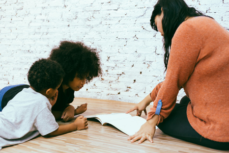 Young mother homeschooling and giving  preschool kids education の写真素材