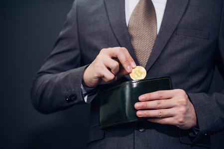 Close-up of businessman with wallet receiving and paying by bitcoin or cryptocurrency - crypto...