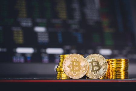 Bitcoin coins pile and two bit coins sitting in front with stock index graph chart digital...