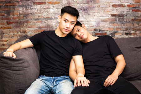 Asian gay couple spending time at home together and looking at camera. Portrait of happy gay men - Homosexual love conceptの写真素材
