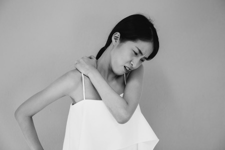 Asian woman having chronic neck and shoulder pain in black and white tone - Healthcare and Medical conceptの写真素材