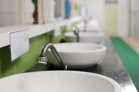 Retro and rusted washing steel faucet and toilet basin interior in WCの写真素材