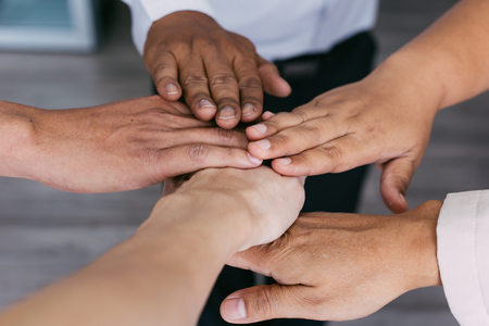 Close up of young business people putting their hands together for unity. Hands stacking over for collaboration and teamworkの写真素材