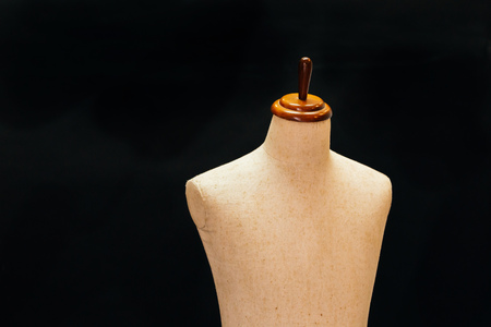 Old and vintage mannequin made of cloth standing in black background lid in 3d - can be used for tailoring and garment conceptの写真素材