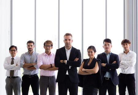 Group of confident business people in various diversity with arms crossed in corporate office...