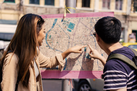 Young Asian couple tourist looking at city map and directions together in Bangkok, Thailand