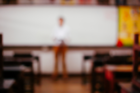 Blurred Background of classroom full of desks and one teacher with copy spaceの写真素材