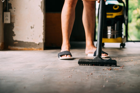 Human legs wearing sandals with industrial vacuum cleaner- cleanliness housekeeping conceptの写真素材