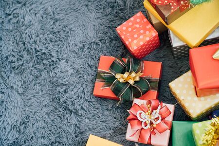 Horizontal top view of colorful gift boxes with ribbons over rustic background - with copy spaceの写真素材