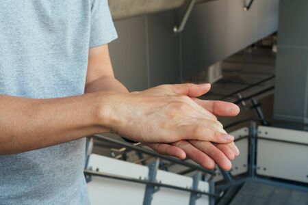Man washing hands and applying alcohol gel to clean and get rid of germ, bacteria at train station. Health care and infection control conceptの写真素材