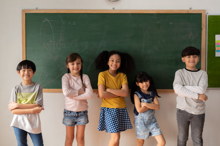 Happy multiethnic children in casual clothes crossing arms and smiling while standing near...