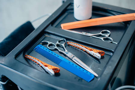 Closeup of tools and equipments like scissors, comb and clips kept on tray for hair cutting in a modern hairdresser barbershopの写真素材