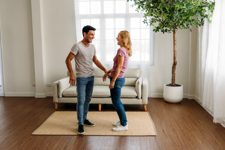 Young and handsome caucasian man and beautiful woman doing romantic couple in love holding hand and spending time together at home and feeling excitedの写真素材