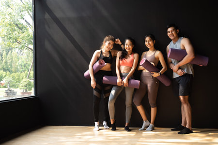 Happy smiling man and women having fun talking in gym. Group of young people relaxing in gym after...
