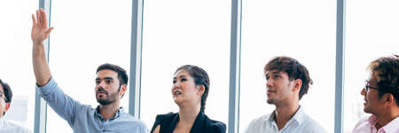 Close-up of senior Caucasian businessman raising hand up alongside with corporate colleagues in seminar discussionの写真素材