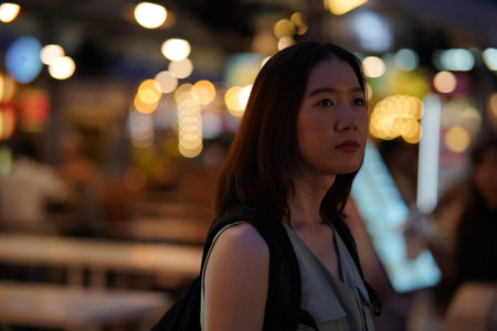 Young Adult Asian woman exploring a street market in Bangkok, Thailand. Female solo traveler on...