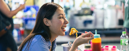 Web Banner of Young Asian woman traveler tourist eating Thai street food in China town night market...