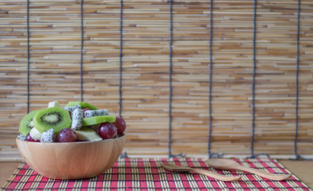 Delicious healthy fruits salad in bowl on tableの写真素材