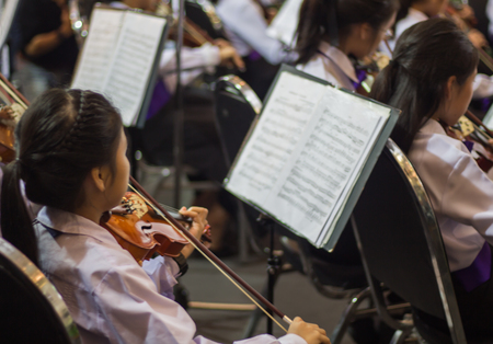 Schoolboy playing the violin in orchestra bandの写真素材