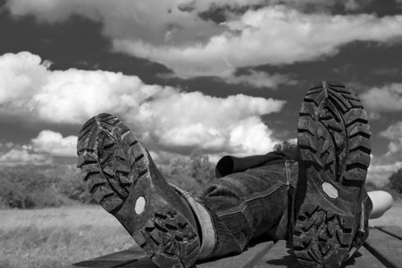 hiker taking a rest on a summer-day.Focus on bottom of hiking-bootsの写真素材