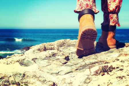 Female Hiking boots closeup on mountain rocks.の写真素材