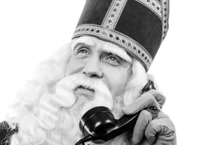 Sinterklaas with old  telephone.Monochrome. isolated on white background. Dutch character of Santa Clausの写真素材