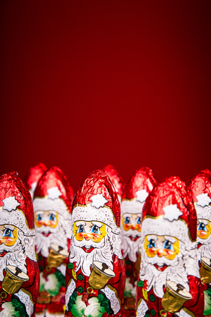 Closeup of Santa Claus chocolate figurine on red backgroundの写真素材