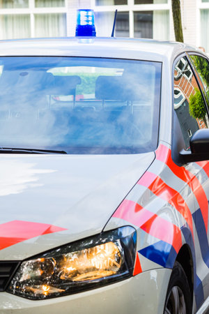 dutch police car with siren and headlights on. Front view