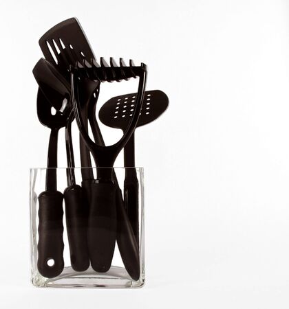 Contemporary black kitchen utensils in a clear glass vase on white                              の写真素材