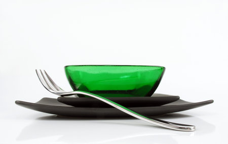 Simple black plates with a single fork and a stunning green bowl                               の写真素材