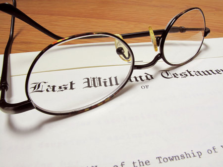 Actual last will and testament with eyeglasses on wooden desk                               の写真素材