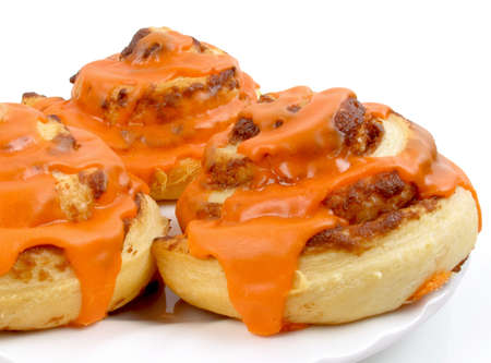 Freshly baked cinnamon rolls with orange icing                               の写真素材