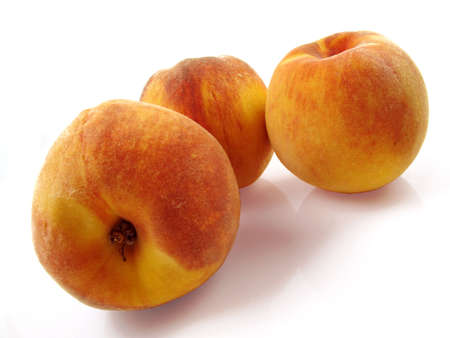 Three ripe, juicy peaches on a white reflective background                               の写真素材