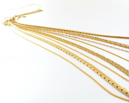 Beautiful gold necklace chains on a white background                               の写真素材
