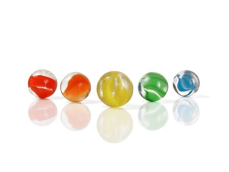 Five colorful marbles isolated and reflected on whiteの写真素材
