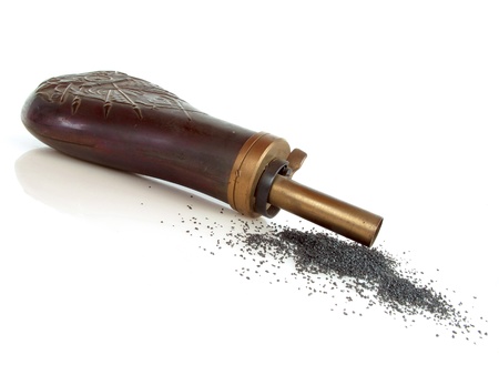 Vintage powder horn with black powder on whiteの写真素材
