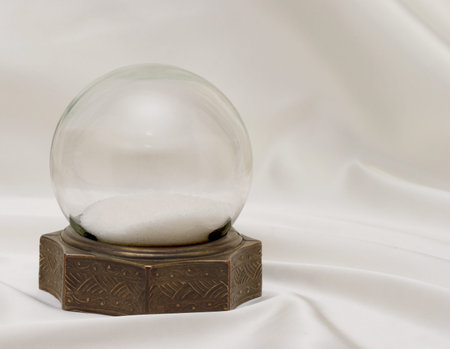 Very old antique snow globe with brass base on white satin