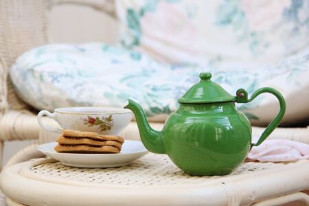 Pretty little teapot with vintage cup and cookiesの写真素材