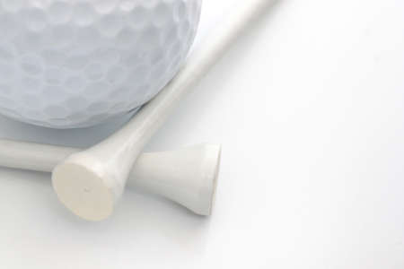 Closeup view of a golf ball with white tees over whiteの写真素材