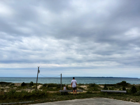 A Young Man and Small Boy Looking at a Lakeの写真素材