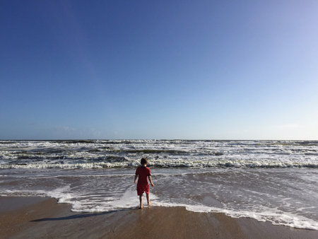 A small child walking on a beachの写真素材