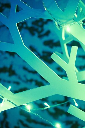 Wooden artificial abstract christmas tree decorated with garlands studio backgroundの写真素材