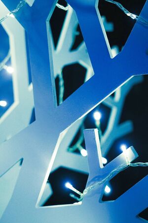 Wooden artificial abstract christmas tree decorated with garlands studio backgroundの写真素材