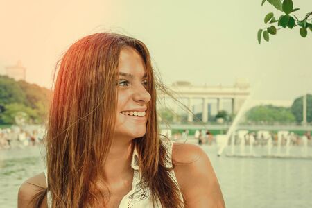 Young attractive brunette dressed skirt and blouse in Moscow summer parkの写真素材