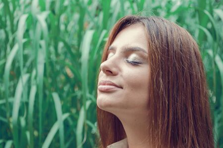 Young attractive brunette dressed skirt and blouse in Moscow summer parkの写真素材