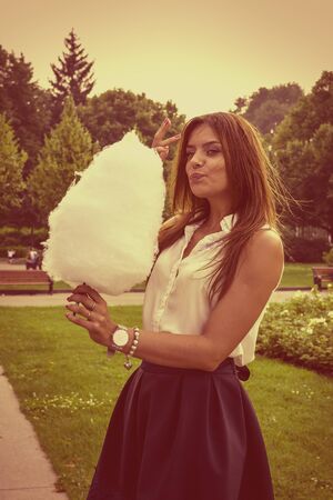 Young attractive brunette dressed skirt and blouse in Moscow summer parkの写真素材